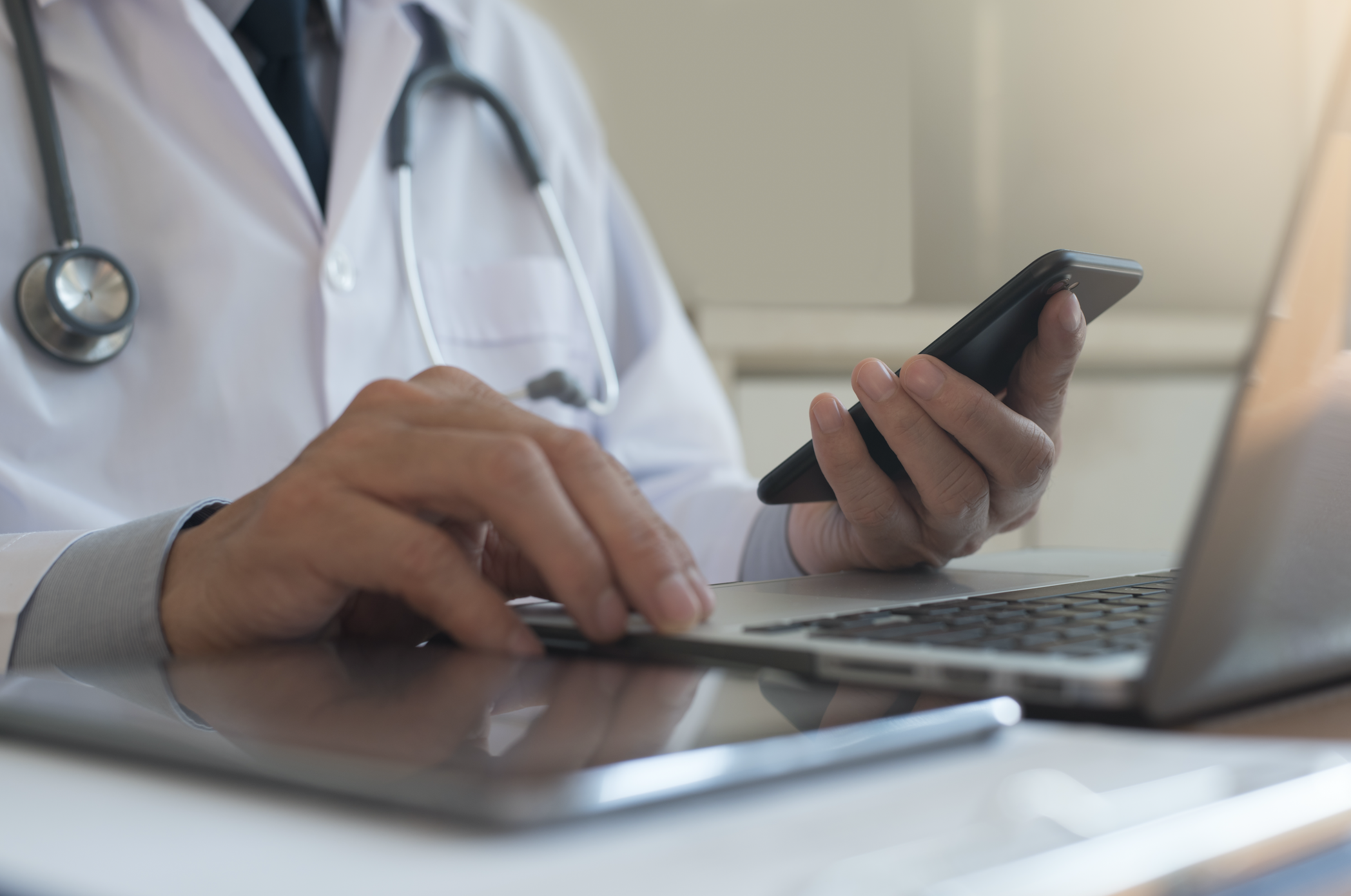 Clinician with mobile phone and computer