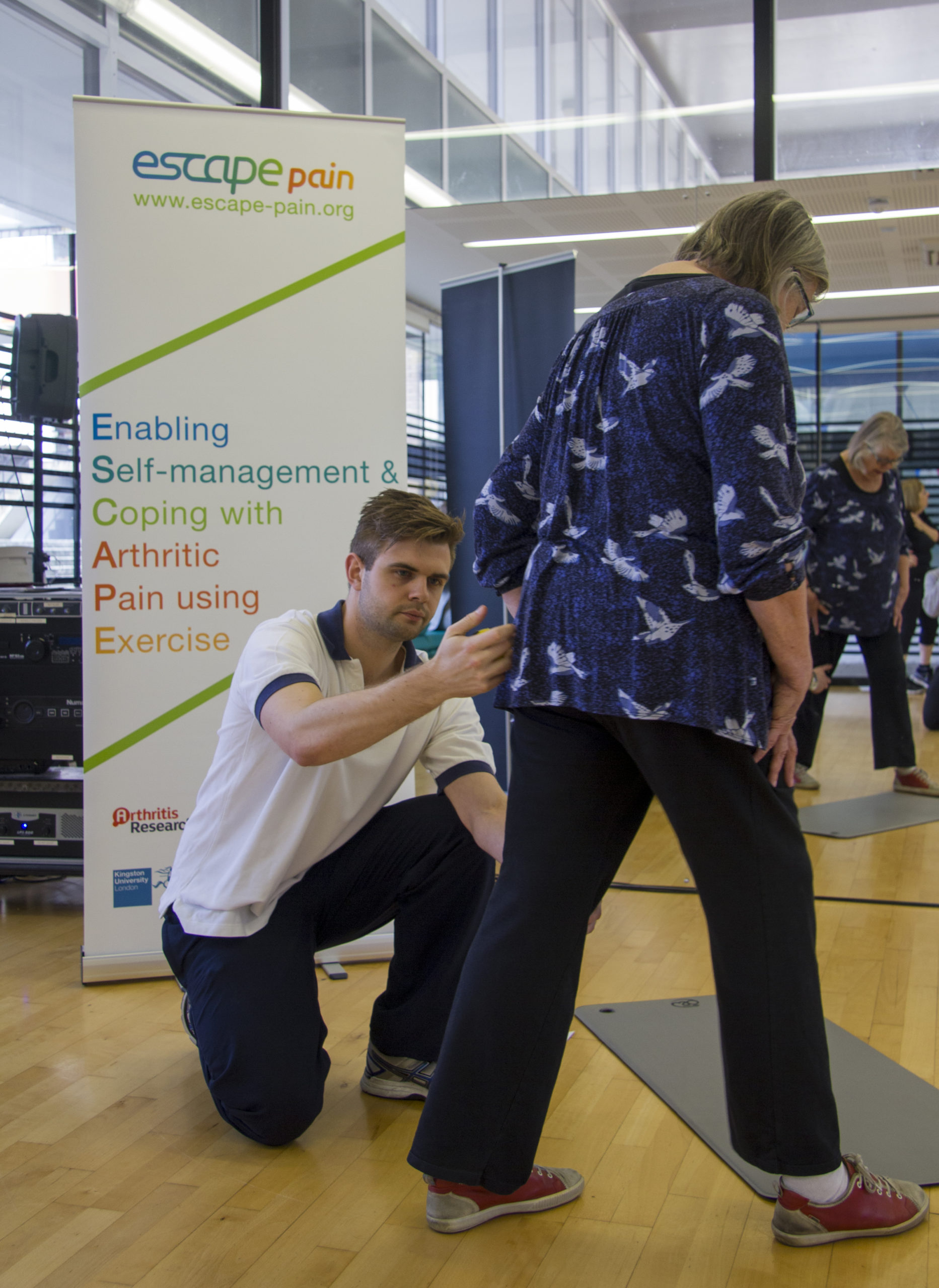 Trainer helps woman exercise