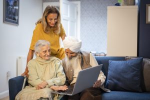 Three people around a laptop