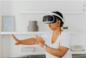 A woman is wearing an augmented reality headset, earphones, and a smart watch. She is taking part in physical rehabilitation using these technologies.